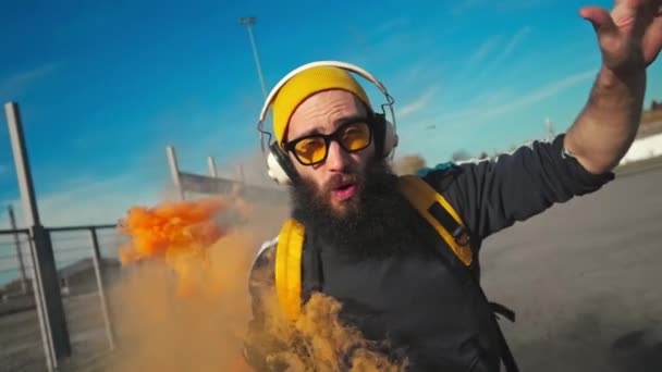 Portret hipstera w żółtych okularach. taniec uliczny z pomarańczowym dymem. Zwolniony ruch — Wideo stockowe
