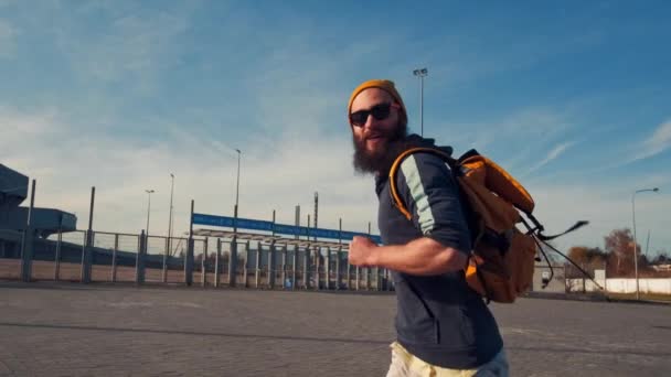 Jeune homme barbu brutal beau courir avec un sac à dos, jour d'automne, style drôle — Video