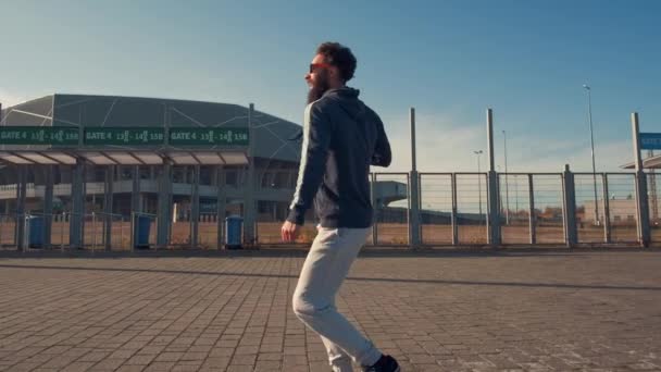 Verrückte junge gut aussehende lustige Mann läuft auf der Stadt Hintergrund Nahaufnahme Zeitlupe. — Stockvideo