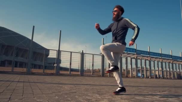 Joven guapo brutal barbudo hombre corriendo con una mochila, día de otoño, estilo divertido — Vídeos de Stock