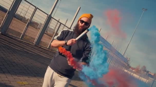 Portrét hipstera ve žlutých brýlích, který tančí street dance s pomerančovým kouřem. Zpomalený pohyb — Stock video