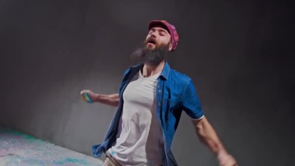 Człowiek tancerz Wyświetlono break-dancing porusza się przed wybuchem kolorowy proszek. — Wideo stockowe