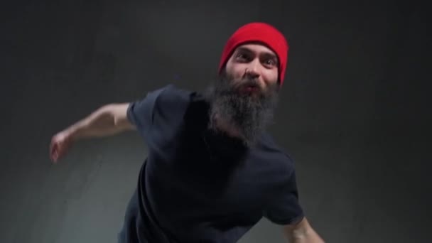 Close-up van een jonge hiphopdanser met rode hoed die stadsdans opvoert in de klas. De jongen beweegt zijn handen tonen freestyle en moderne dans. — Stockvideo