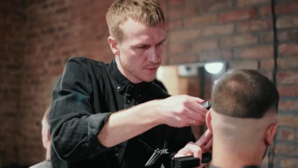 Mannelijk kapsel met elektrisch scheermes. Sluiten van de man haar geknipt. Mannelijke handen kapper scheren man met elektrische scheermes in kapperszaak. Kapper knippen haar met haar trimmer. — Stockvideo