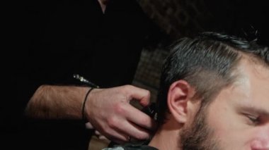 Erkek saç kesimi ile tıraş. Düzeltici saç yakın çekim. Profesyonel kuaför kesim saç saç kesme makinesi ile. Adam kuaförlük ile Elektrikli tıraş makinesi