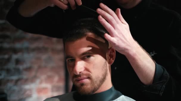 Friseur schneidet dem Kunden die Haare mit der Schere aus nächster Nähe. Rahmen. Friseur kämmt Haare und schneidet mit Friseurschere. — Stockvideo