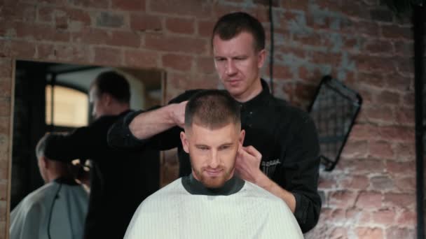 Corte de pelo masculino con afeitadora eléctrica. Cierre de corte de pelo de hombre. Hombre manos peluquero afeitado hombre con maquinilla de afeitar eléctrica en la barbería. Peluquero corte de cabello con cortador de pelo. — Vídeos de Stock