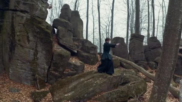 Uomo in abiti tradizionali giapponesi, con una spada, una katana, allena arti marziali sullo sfondo della foresta — Video Stock