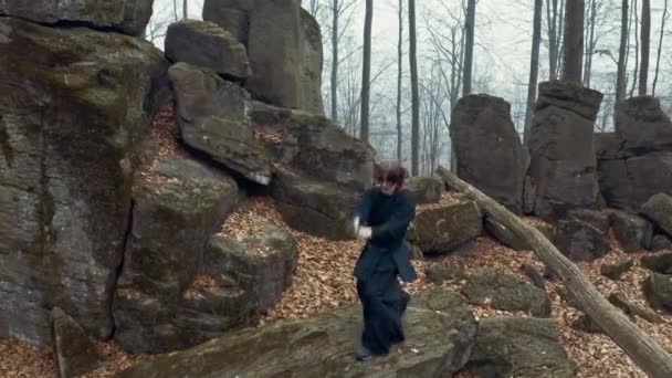 Homme uniforme traditionnel tient un katana dans un fond de forêt vert flou 4k . — Video