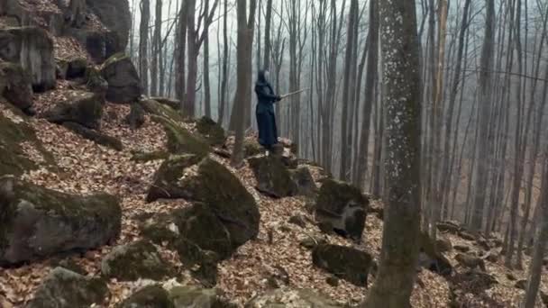 Сконцентрированный человек с японским мечом, катана, практикующая иайдо в сосновом лесу. Широкий угол. Вид сзади . — стоковое видео
