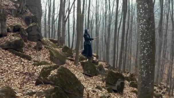 Koncentruje się człowiek z japoński Miecz katana praktykujących Iaido w sosnowym lesie. Szeroki kąt. Widok z tyłu. — Wideo stockowe