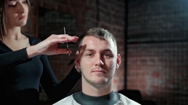 Beleza, penteado e conceito de pessoas - homem sorridente feliz e estilista ou cabeleireiro com trimmer fazendo corte de cabelo no salão de cabeleireiro . — Vídeo de Stock