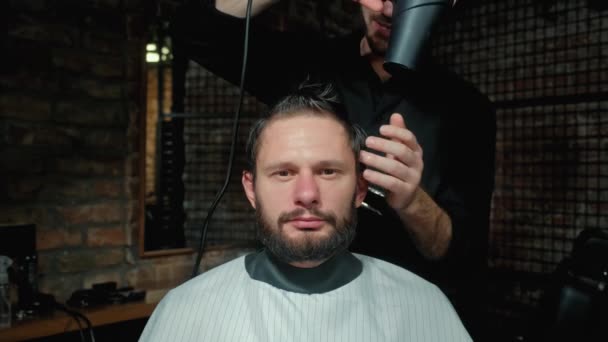 Beauty, Frisur und People-Konzept - glücklich lächelnder Mann und Stylist oder Friseur mit Trimmer beim Friseur. — Stockvideo