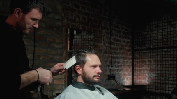 Concepto de belleza, peinado y gente - hombre sonriente feliz y estilista o peluquero con trimmer haciendo corte de pelo en el salón de belleza . — Vídeos de Stock