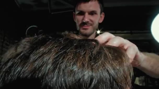 Vue rapprochée sur la coiffure masculine dans un salon de coiffure avec tondeuse professionnelle. Mans coupe de cheveux au salon de coiffure avec tondeuse électrique. Le toilettage des cheveux. Mouvement lent . — Video