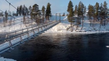 Aerial Shot Of River And Suspension Bridge With A Winter Background