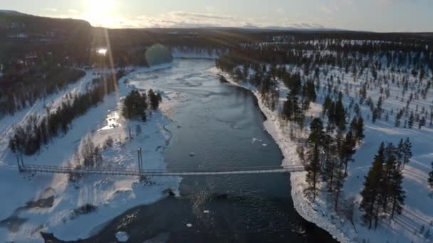 Plano aéreo de río y puente colgante con un fondo de invierno — Vídeo de stock