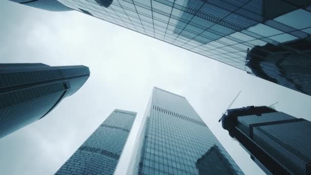 Panoramic view of modern skyscrapers made of glass. Camera movement from bottom to top, rotation, then from top to bottom. Blue sky. Evening, no people — Stock Video