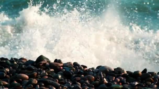 Die Wellen brechen an einem steinigen Strand, blaues Wasser — Stockvideo