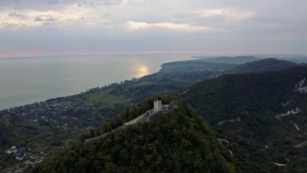O drone mostra a beleza velha da fortaleza de Anacopia e do mar Negro surpreendente com linha de costa longa que conecta com a cidade, o vale e as colinas verdes no dia ensolarado do verão com céu azul cristal surpreendente . — Vídeo de Stock