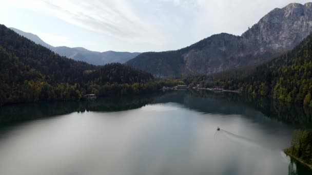 Aerial shot of beautiful alpine lake Ritsa speed boat floating summer, View from Above on Gorgeous Lake Ritsa between mountains in Nation Park, clear water, pristine nature. — Stock Video