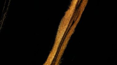 Altın sarısı renkler. Siyah akıntılar altın halkalarla yana akın eder. yavaş çekimde