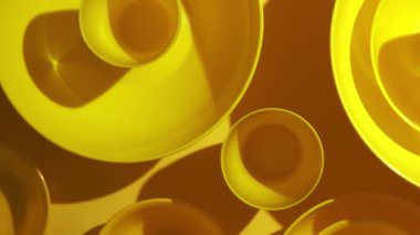 yellow plastic bowls are placed in layers for background texture.