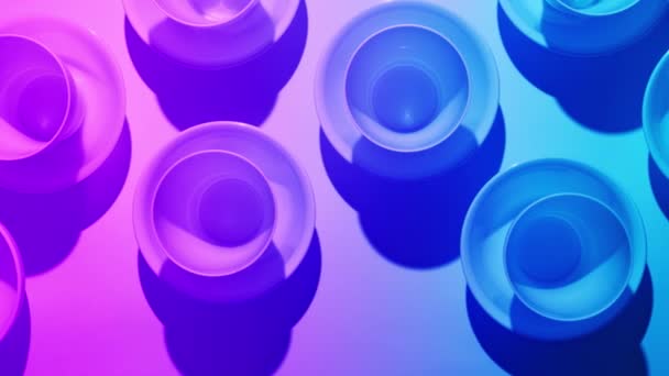 Bowls on a pink table with shades of blue, top view. Beautiful abstract background — Stock Video