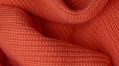 örülmüş turuncu yün bir kazağın yüzeyi.