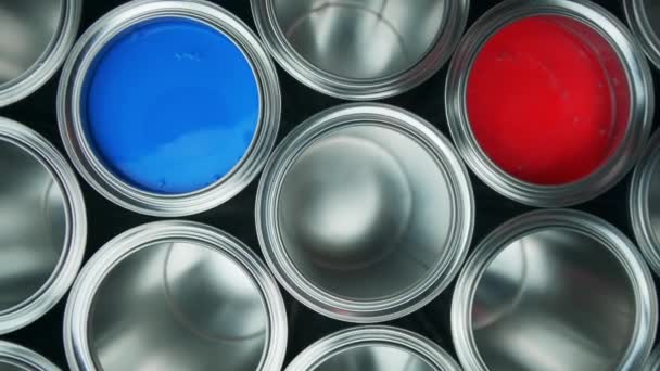 Abre latas de pintura sobre un fondo negro. rojo y azul — Vídeo de stock
