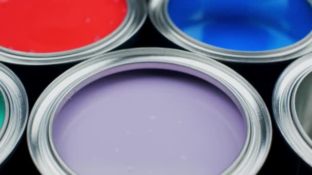 Открыть многоцветные банки краски на сером фоне, вид сверху — стоковое видео