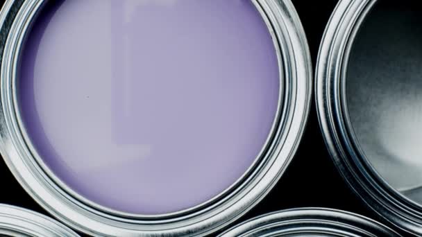 Open multicolor paint cans on grey background, top view — Stock Video