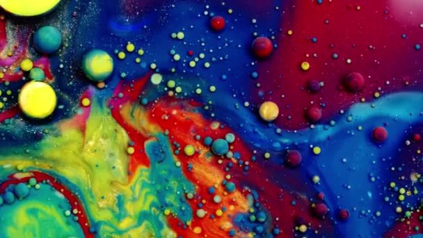 Multicolore bolle di collari luminosi che si muovono nella superficie dell'olio di vernice bellissimo universo blu di colore rallentato macro rosso blu nero e giallo — Video Stock