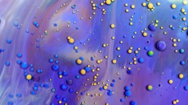 Boyanın içinde kabarcık sıvısı yüzer. Boya, yağ ve süt karışımı. Muhteşem renkli ve parlak bir arka plan, kozmetik efekt. Soyut renkli boya ve yavaş çekim.