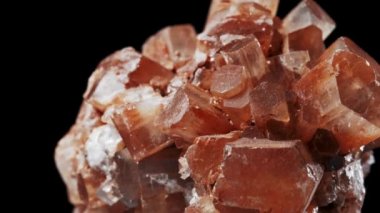 Kan turuncu bir minerali kusursuz bir şekilde siyah arkaplan önünde döndürüyor.