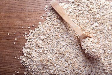 Tahta kaşık yulaf gevreği zemin üzerine yulaf gevreği. Sağlıklı beslenme ve yaşam tarzı.