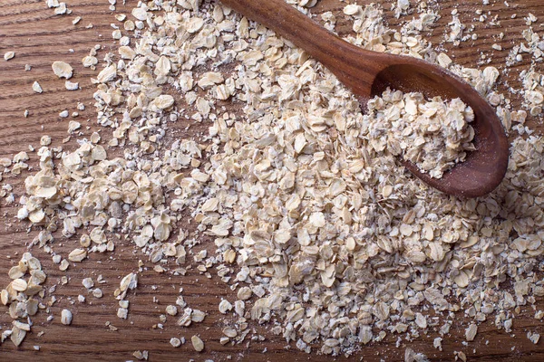 Copos de avena con cuchara de madera —  Fotos de Stock