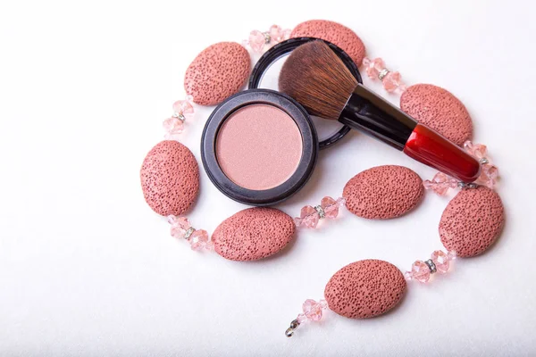 Overhead close up of one open jar of spilled pink blush powder with thick tipped brush on a white background — Stock Photo, Image