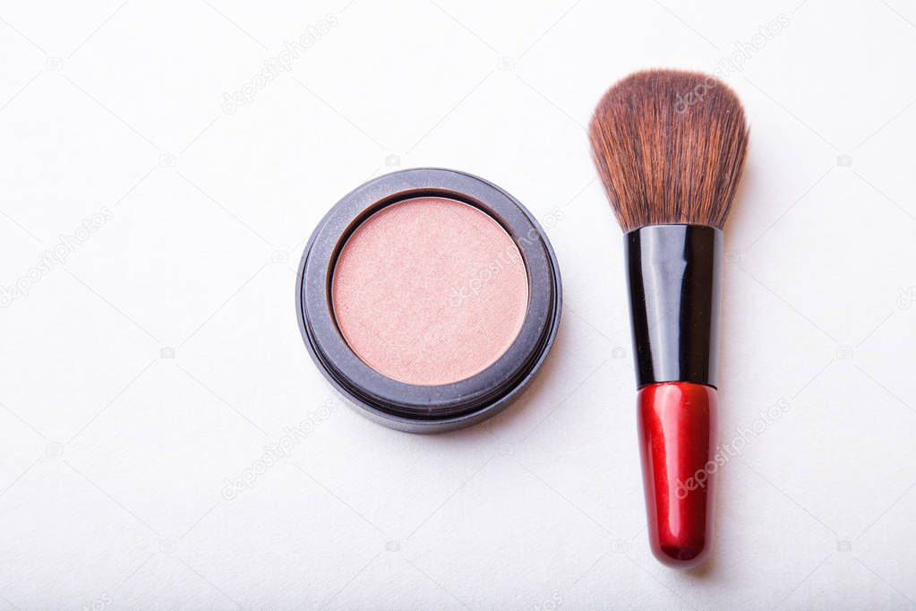 makeup brush and cosmetic powder isolated on white background