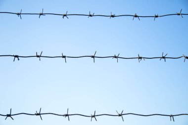 Mavi gökyüzünde dikenli teller