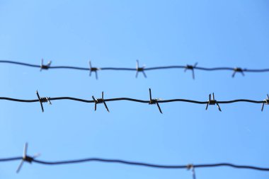 Mavi gökyüzü arka planında dikenli tel