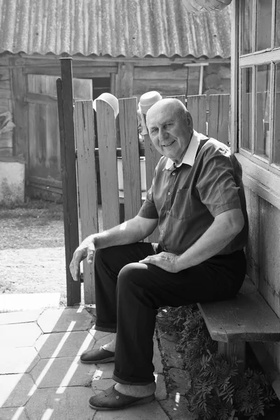 Yaşlı adam bir bankta oturan sahiptir. Siyah beyaz portre — Stok fotoğraf