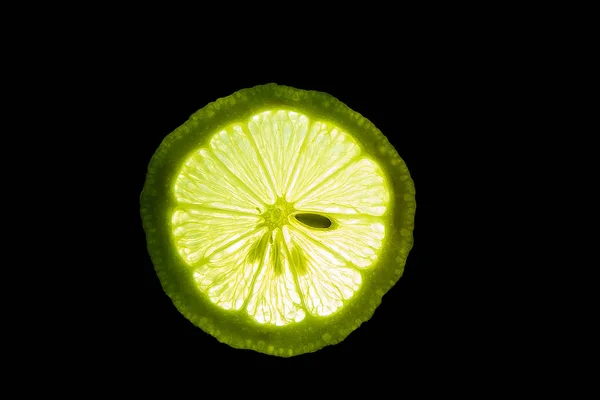 Fatia de Limão maduro isolado em um fundo escuro — Fotografia de Stock