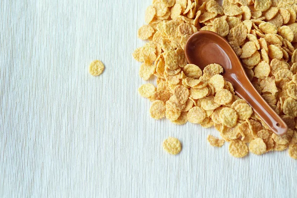 Cornflakes dans une cuillère sur fond de cornflakes. Gros plan . — Photo