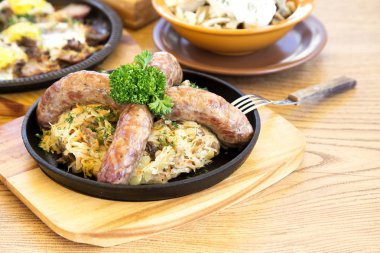 Bir tava üzerinde lahana turşusu ile sosis