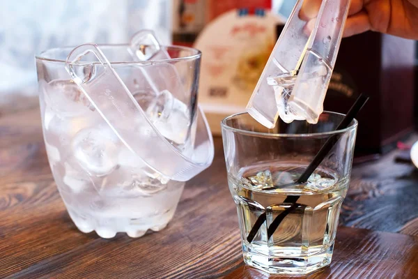 Pedaços de gelo e um copo com álcool — Fotografia de Stock