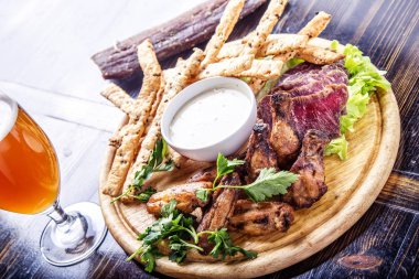 Lezzetli et yemek ızgara tavuk kanadı ile domuz eti et ve peynir sopa ahşap tahta üzerinde tedavi