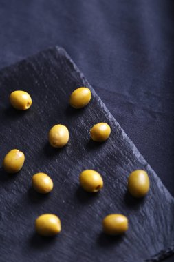 Kara tahta üzerinde yeşil zeytin 