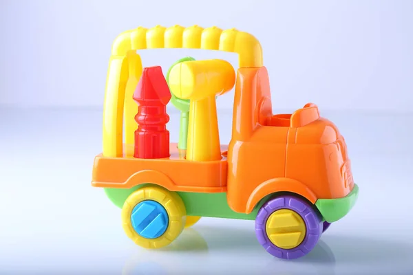 Brinquedo de caminhão de plástico com ferramentas no fundo branco — Fotografia de Stock