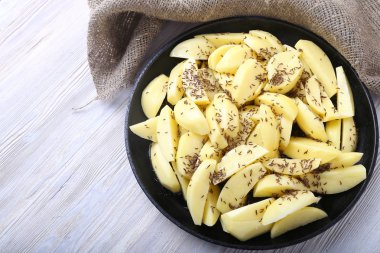 Kimyon tohumu bir tavada ile ham patates. Üstten Görünüm